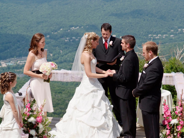 Bride and groom standing at the top of the mountain with their wedding party during the ceremony in the White Mountains in Lincoln, NH