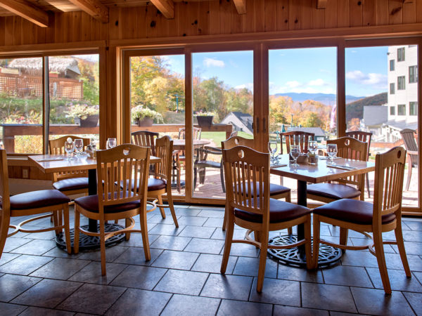 Dining tables in the breakfast area with large windows and a view of the White Mountains in Lincoln, NH
