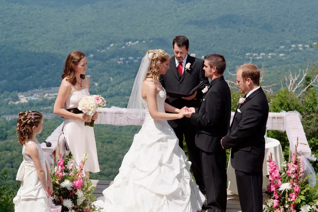 Bride and groom standing at the top of the mountain with their wedding party during the ceremony in the White Mountains in Lincoln, NH