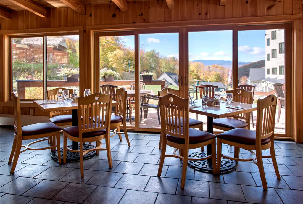 Dining tables in the breakfast area with large windows and a view of the White Mountains in Lincoln, NH